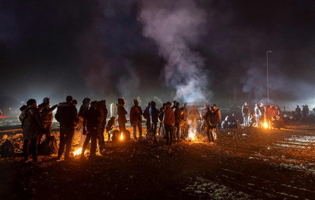 सन् २०२३ डिसेम्बर ६ मा अमेरिका-मेक्सिको सीमामा रहेको एरिजोनामा अवैध रूपले अमेरिका प्रवेश गरेकाहरू न्यानो हुन आगो ताप्दै। तस्बिर: जोन मोर/एएफपी