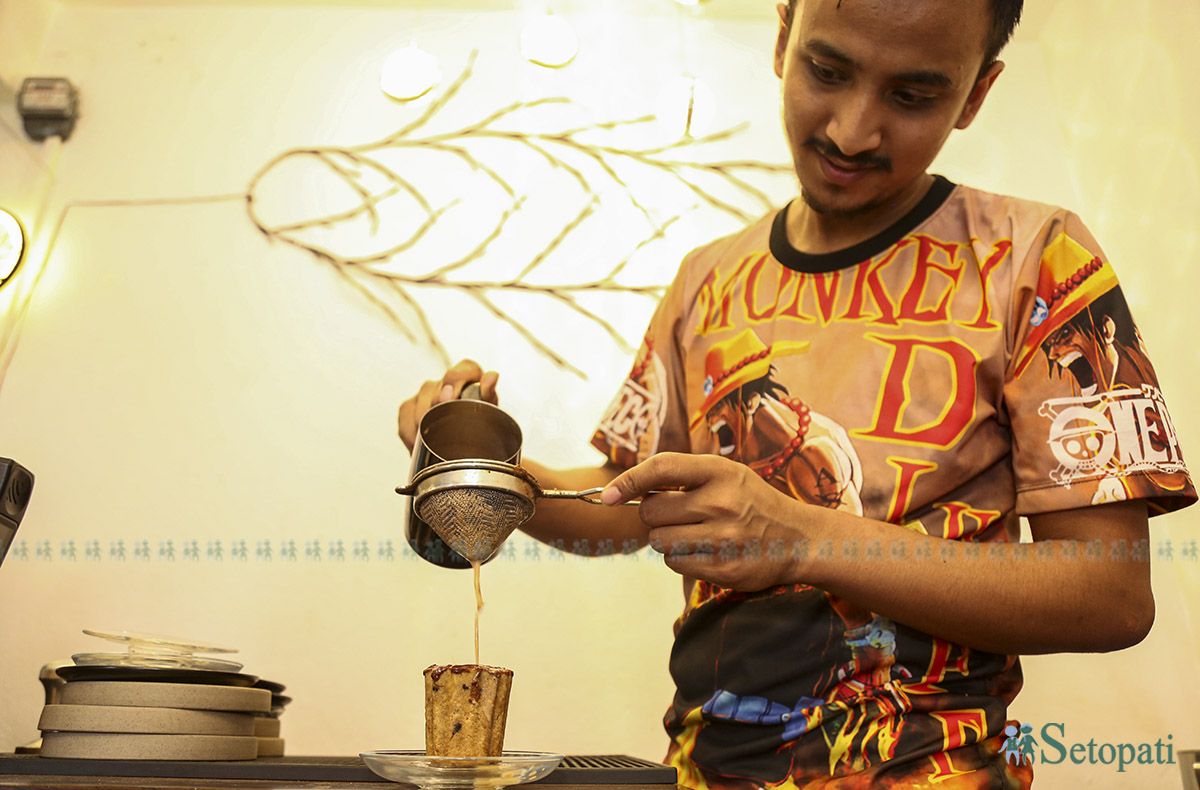 कुकी कपमा चिया हाल्दै कोटेश्वरस्थित 'ल्याटी लभर्स' क्याफेका कर्मचारी। तस्बिर: नवीनबाबु गुरूङ/सेतोपाटी